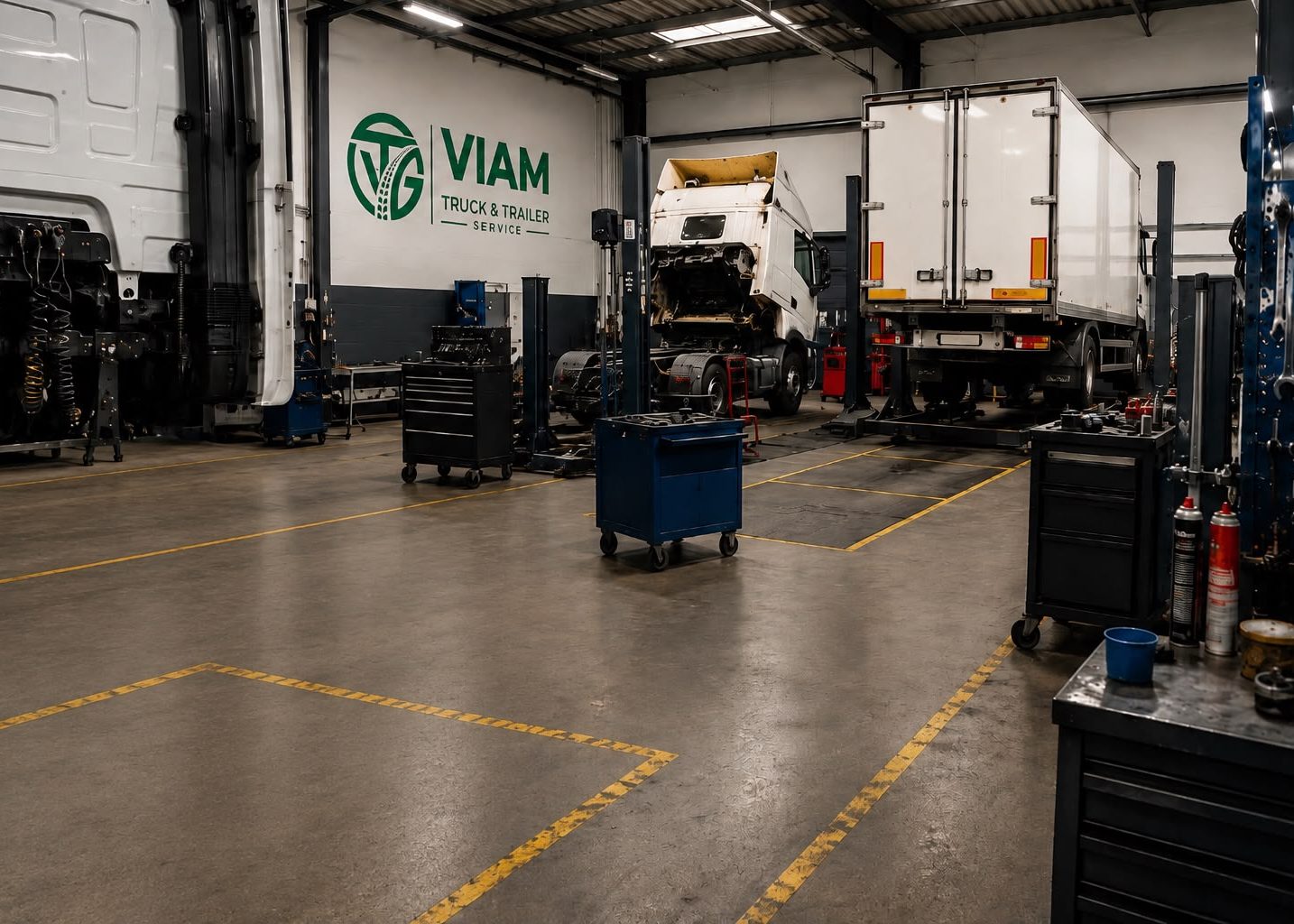 Werkplaats van Viam Truck & Trailer Service in De Bilt met trucks op de brug en gereedschapswagens