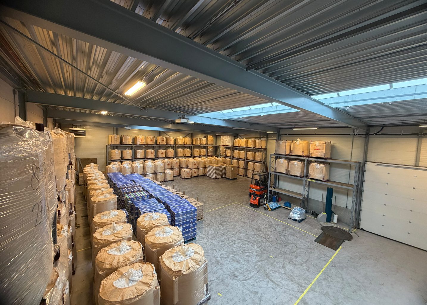 Opslaghal van Viam Storage & Repair in Houten met big bags, pallets in stellingen en een heftruck